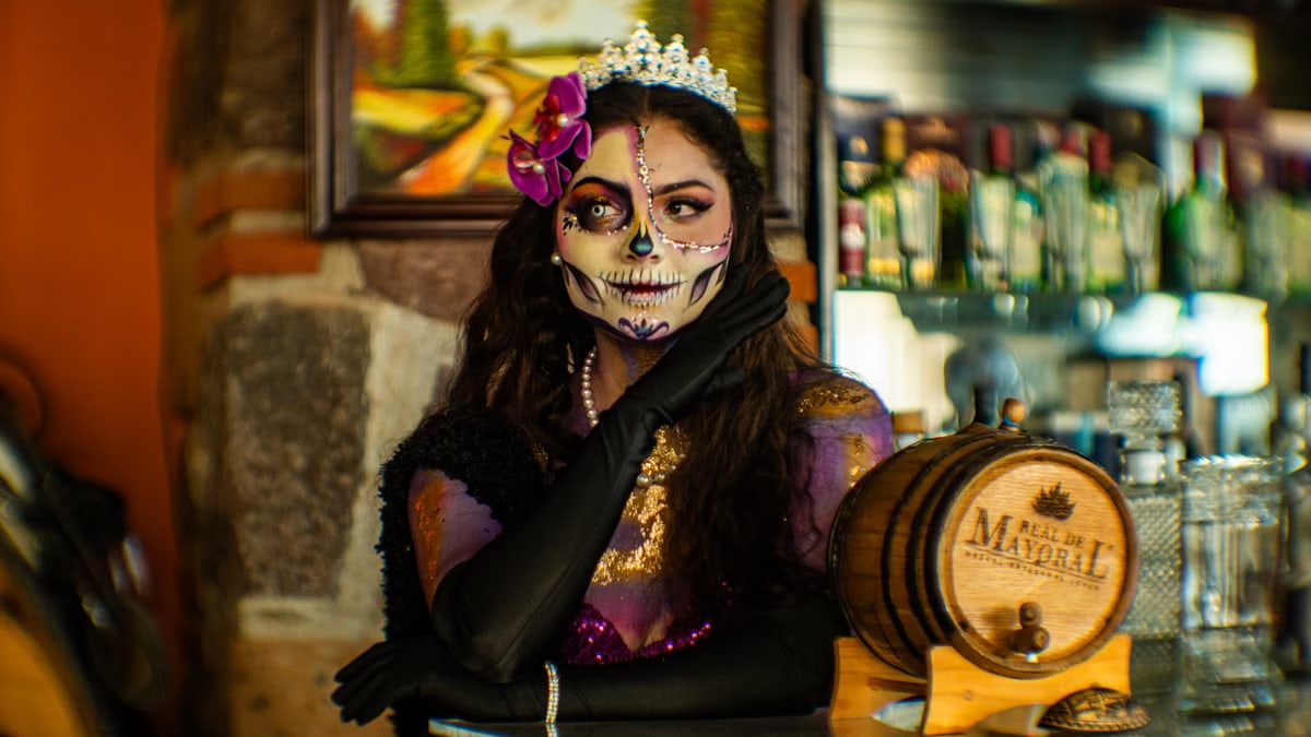 Colorful Catrina makeup and costume in a Mexico City bar setting.