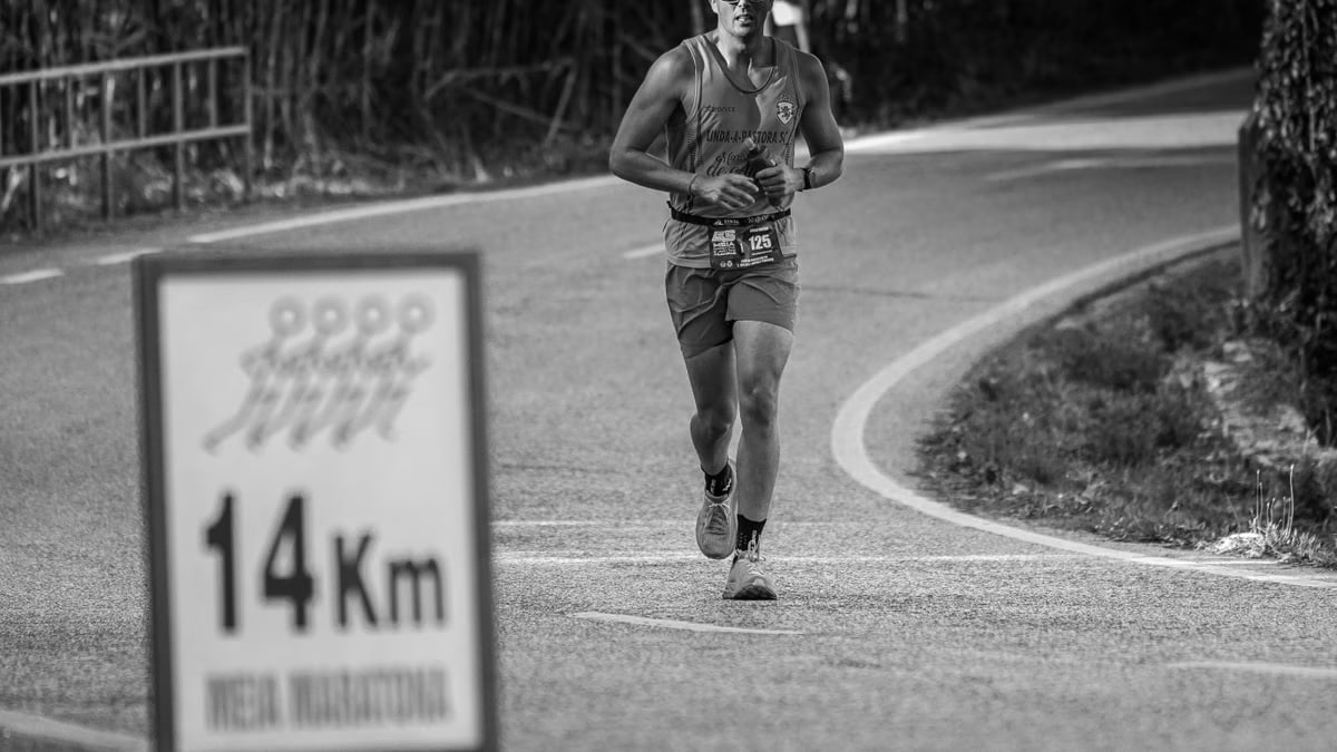 A determined runner participating in a marathon at the 14Km mark on outdoor city streets.